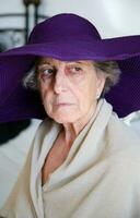 Old caucasian woman in a violet hat photo