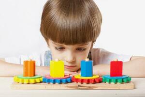 Six years old boy is playing with building gear set. photo