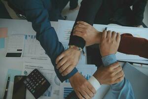 Close up top view of young business people putting their hands together. Stack of hands. Unity and teamwork concept. photo