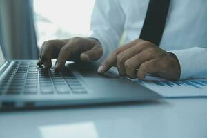 Close up businessman hand using calculator and working with laptop calculate about finance accounting at coffeeshop outdor.finance accounting concept photo