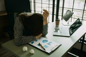 Asian women are stressed while working on laptop, Tired asian businesswoman with headache at office, feeling sick at work, copy space photo