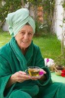 A senior takes her tisane in an open air spa studio photo