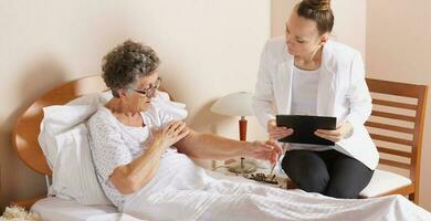 Visit of senior social work assistant to an old woman photo