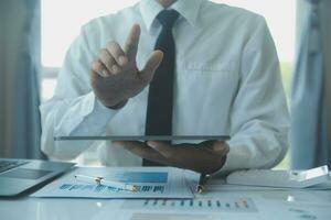 Close up businessman hand using calculator and working with laptop calculate about finance accounting at coffeeshop outdor.finance accounting concept photo