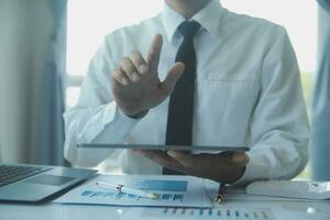 Close up businessman hand using calculator and working with laptop calculate about finance accounting at coffeeshop outdor.finance accounting concept photo