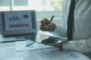 Close up businessman hand using calculator and working with laptop calculate about finance accounting at coffeeshop outdor.finance accounting concept photo