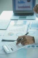 Close up businessman hand using calculator and working with laptop calculate about finance accounting at coffeeshop outdor.finance accounting concept photo