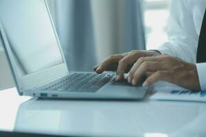Close up businessman hand using calculator and working with laptop calculate about finance accounting at coffeeshop outdor.finance accounting concept photo