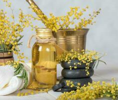 mimosa flores masaje petróleo en vaso botella. foto