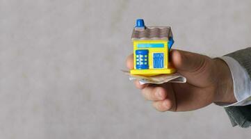 A man keeps a rubber house. Closeup photo