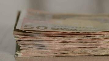 Pile of banknotes of 50 euros on a table. Extreme closeup video