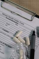 Mental health intake form and a pen on a table. photo