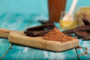 Carob pods and powder on a wooden surface. photo