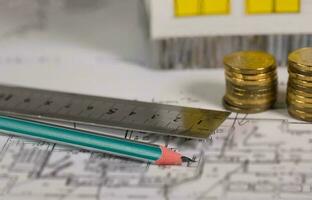 Coal pencil and metal ruler on a technical drawing of an apartment. photo