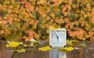 Old square alarm clock on a marble stone covered by rain. photo