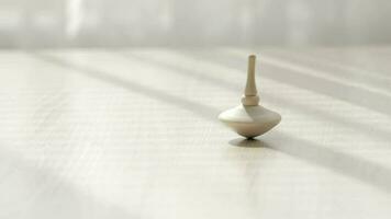 Small spinning top moving on a table with negative space. video