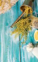 vaso de agua, mimosa flores, panal y piezas de limón foto