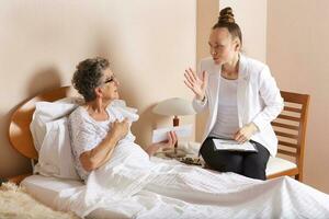 Visit of senior social work assistant to an old woman photo