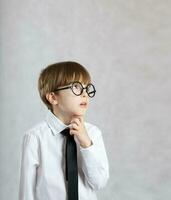 Boy dressed in white shirt with black tie is observing something photo