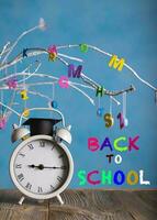 White vintage alarm clock with black academic cap on the top. Back to School photo