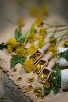 Softgels of dandelion extract on wooden spoons. photo