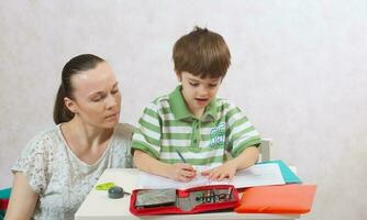 The mother checks the homework of her son photo