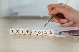 Word EXIT POLL composed of wooden letters. photo