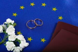 Flag of EU ,two marriage rings,passes. Top view photo