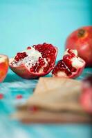 Pomegranate fruit on a cyan wooden surface. photo