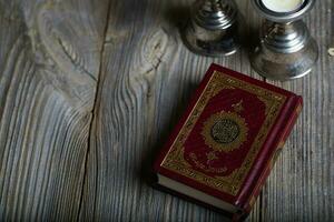 Quran and candles on a wooden surface. photo