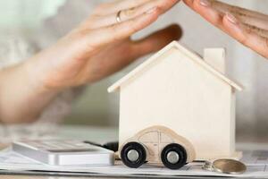 Small wooden car in front of a wooden house. photo