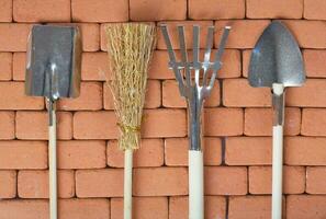 Agricultural tools on a brick wall. Background. photo
