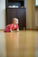 A baby is crawling in a living room photo