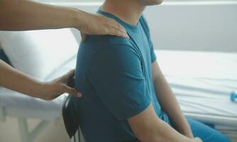 Doctor or Physiotherapist working examining treating injured arm of athlete male patient, stretching and exercise, Doing the Rehabilitation therapy pain in clinic. photo