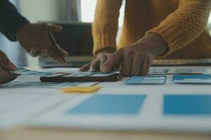 Close up ux developer and ui designer brainstorming about mobile app interface wireframe design on table with customer breif and color code at modern office.Creative digital development agency photo