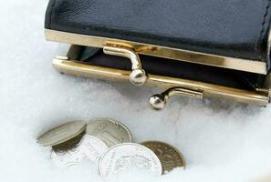 Small parcel and coins in the snow. photo