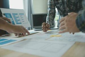 Close up ux developer and ui designer brainstorming about mobile app interface wireframe design on table with customer breif and color code at modern office.Creative digital development agency photo
