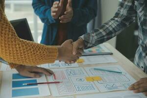 Close up ux developer and ui designer brainstorming about mobile app interface wireframe design on table with customer breif and color code at modern office.Creative digital development agency photo