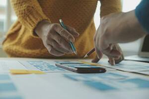 Close up ux developer and ui designer brainstorming about mobile app interface wireframe design on table with customer breif and color code at modern office.Creative digital development agency photo