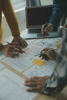 Close up ux developer and ui designer brainstorming about mobile app interface wireframe design on table with customer breif and color code at modern office.Creative digital development agency photo