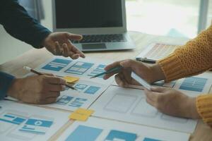 Close up ux developer and ui designer brainstorming about mobile app interface wireframe design on table with customer breif and color code at modern office.Creative digital development agency photo