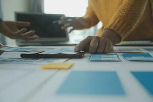 Close up ux developer and ui designer brainstorming about mobile app interface wireframe design on table with customer breif and color code at modern office.Creative digital development agency photo