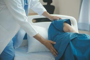 Professional orthopedist examining little patient's leg in clinic photo