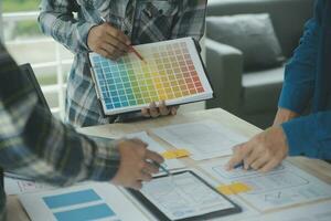 Close up ux developer and ui designer brainstorming about mobile app interface wireframe design on table with customer breif and color code at modern office.Creative digital development agency photo