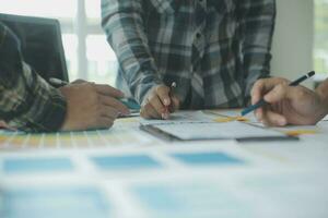 Close up ux developer and ui designer brainstorming about mobile app interface wireframe design on table with customer breif and color code at modern office.Creative digital development agency photo
