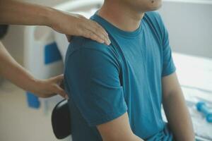 Doctor or Physiotherapist working examining treating injured arm of athlete male patient, stretching and exercise, Doing the Rehabilitation therapy pain in clinic. photo