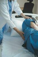 Professional orthopedist examining little patient's leg in clinic photo