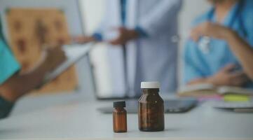 medical team having a meeting with doctors in white lab coats and surgical scrubs seated at a table discussing a patients records,success medical health care, Medicine doctor's working concept photo