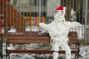 Handmade snowman with red hat made from natural snow photo