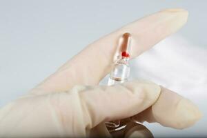 Glass ampule with medication in the hand of medical sister. photo